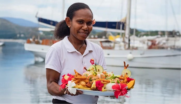 Waterfront Bar & Grill staff holding a seafood platter by the Port Vila harbour
