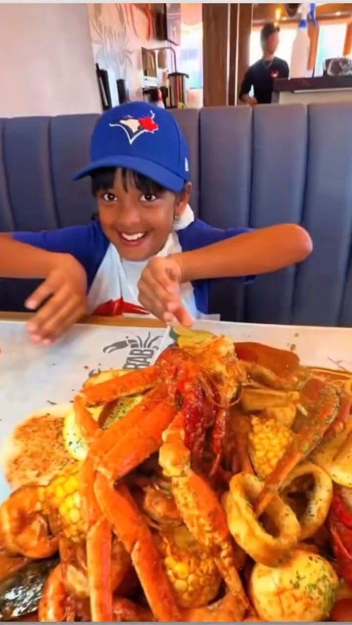 A young diner cracking crab legs at Pirata Crab