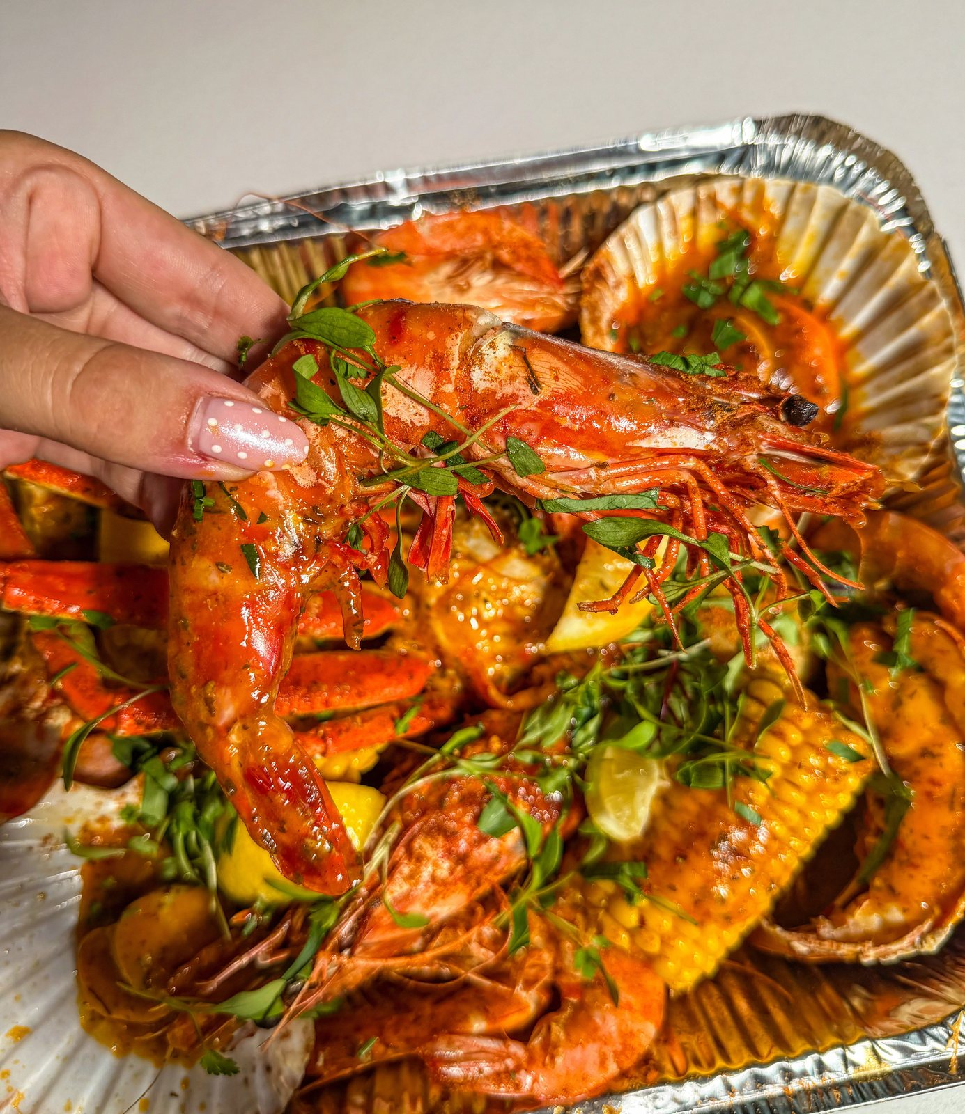Hand holding XXXL king prawn over boil