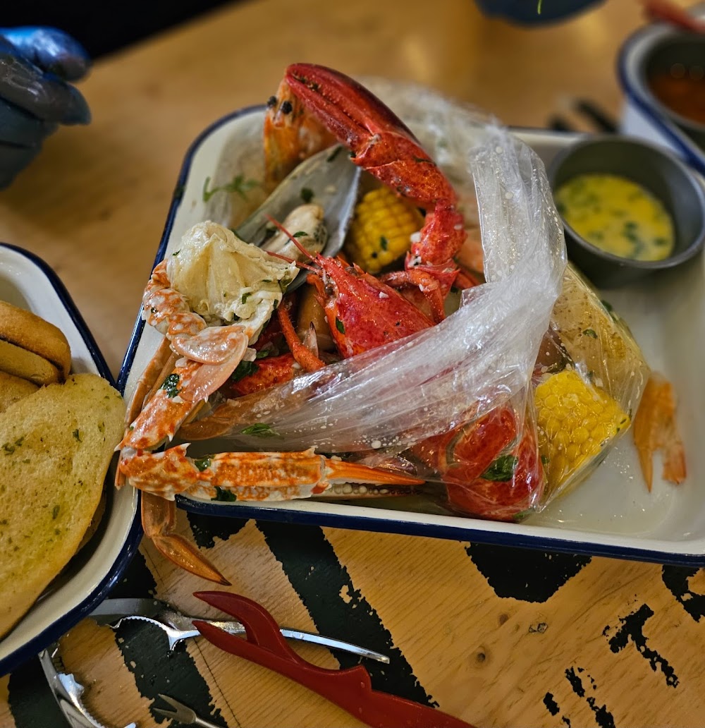Lobster bag with brown crab add-on, sauce pot and garlic bread — dine-in at the food hall